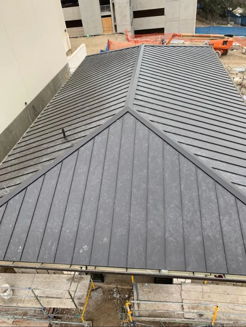 Commercial metal roof construction with crane equipment in North Castle